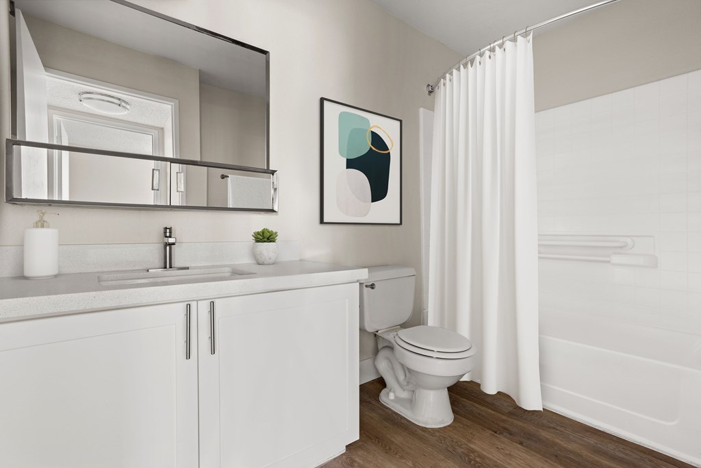 a bathroom with white cabinets and a white shower curtain